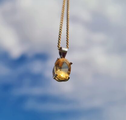 A Jemagic natural citrine pendant, with a cloudy sky background.