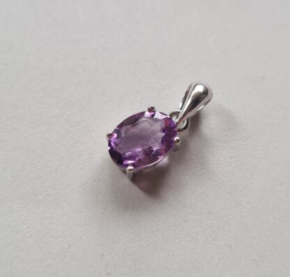Jemagic amethyst pendant on silver background - side view