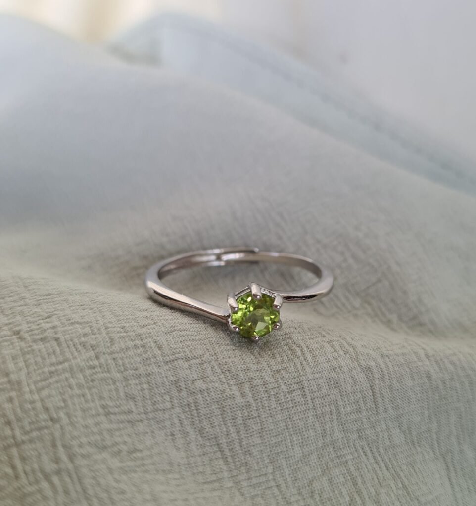 Jemagic peridot ring on green fabric background