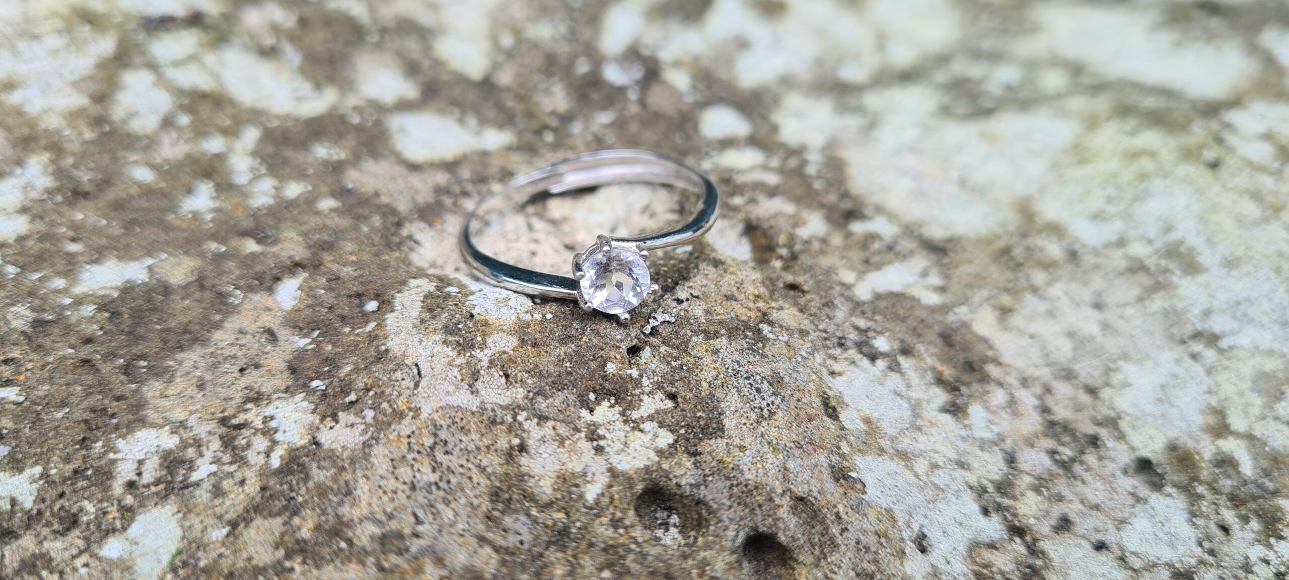 Jemagic White Topaz Ring on Rock Background