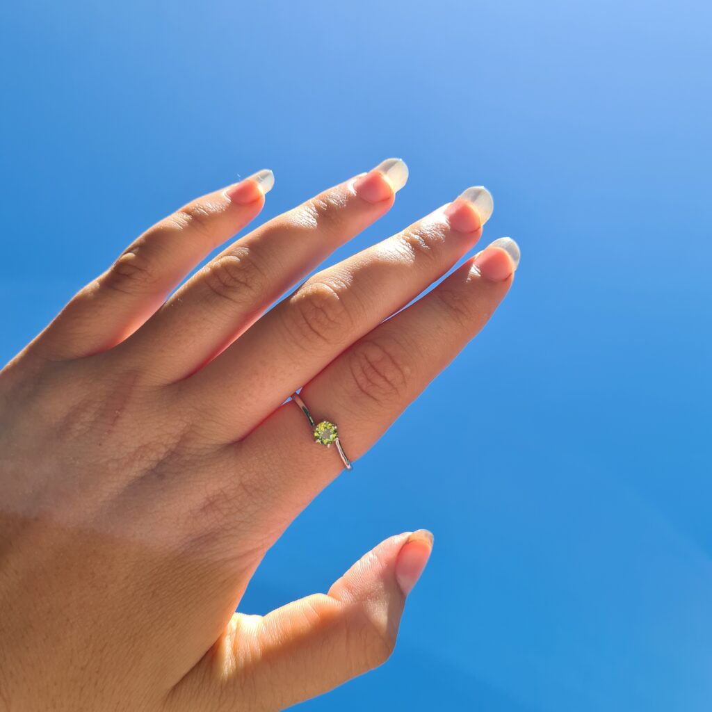 Jemagic Peridot Ring being worn with blue sky background