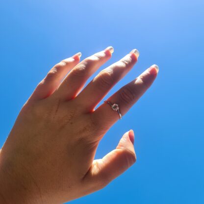 Jemagic Rose Quartz Ring being worn with blue sky background