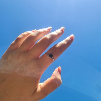 Jemagic Black Spinel Ring being worn with blue sky background