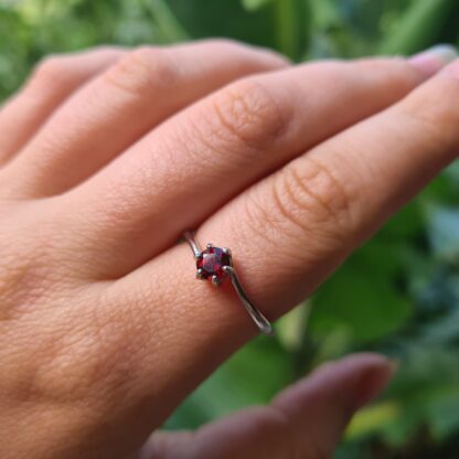Jemagic garnet ring being worn on index finger
