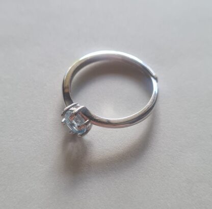 Jemagic blue topaz ring on silver background - side view