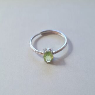 Oval cut Jemagic peridot ring on silver background