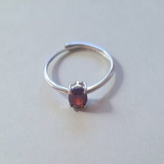 Oval cut Jemagic garnet ring on silver background