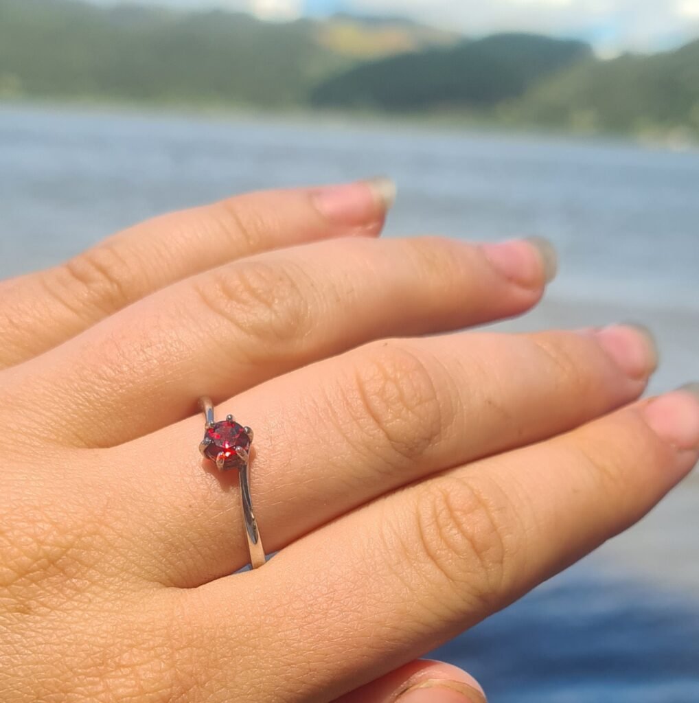Jemagic Instagram post featuring a garnet ring and sea